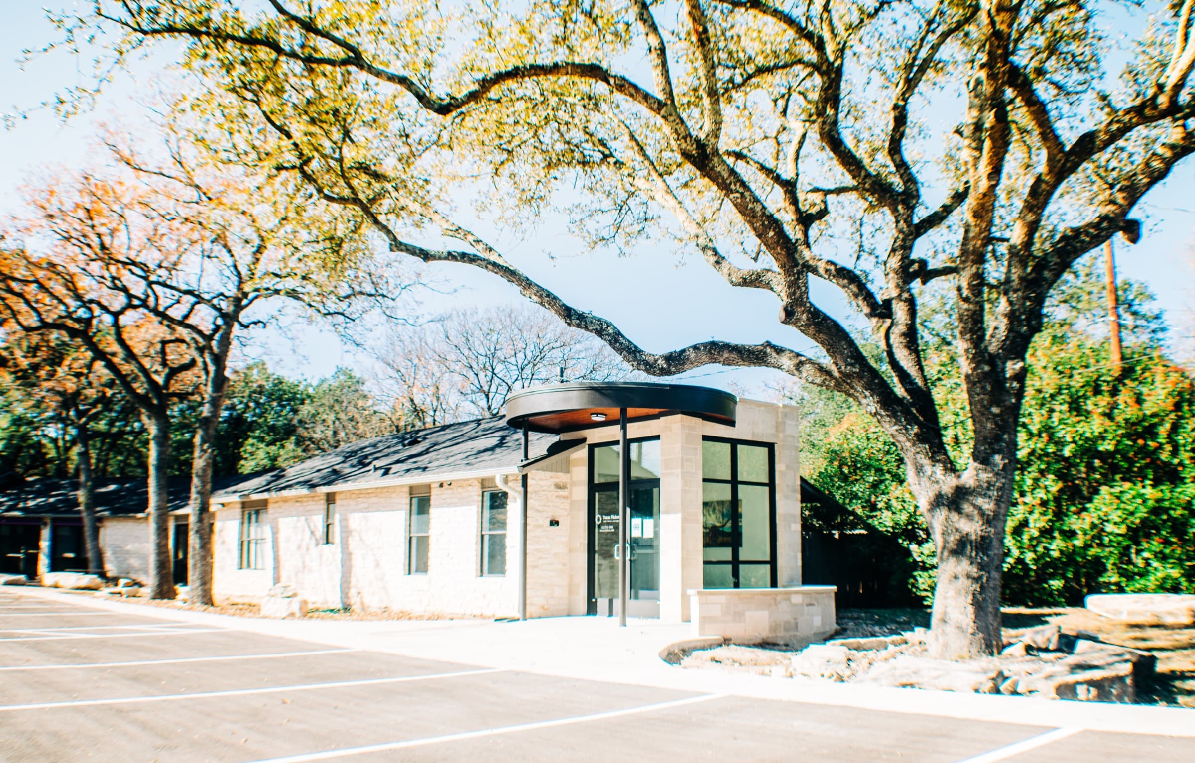 The Texas Vision Georgetown office, a stone building set among Texas hill-country oaks